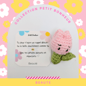 Un crochet de tulipe rose clair avec une tige et des feuilles vertes. La tulipe a un visage souriant avec des yeux noirs.