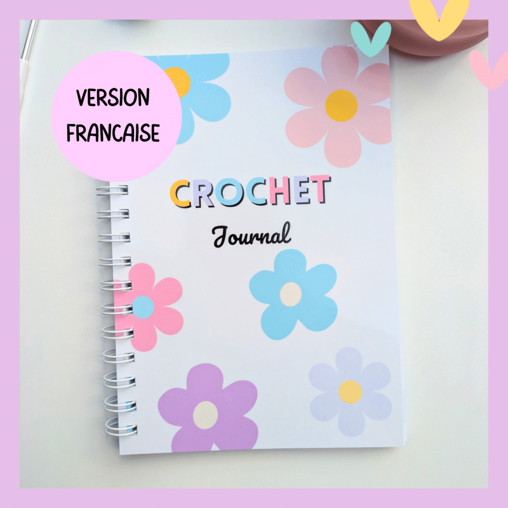 journal de crochet à spirale avec couverture motif fleur ton pastel posé sur une surafce blanche